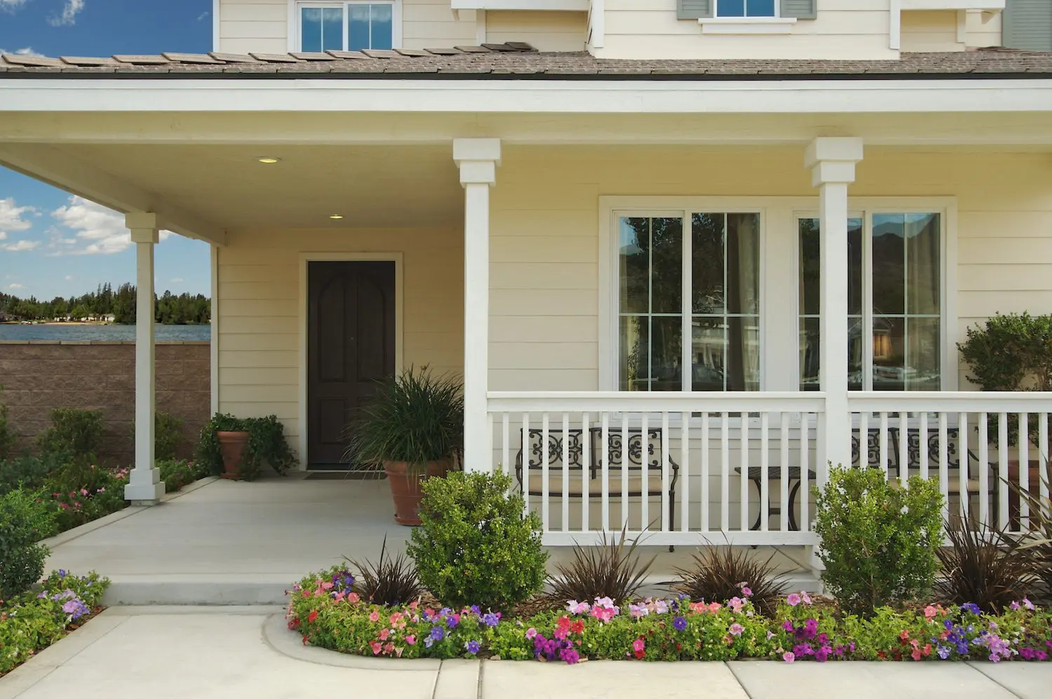 Front porch of traditional looking home with flowers.